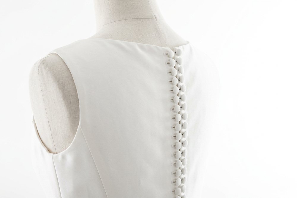 Dos de robe boutonné : rangée de boutons recouverts sur du mikado.