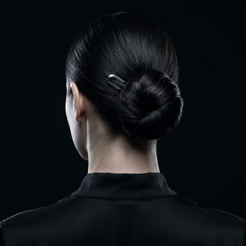 Chignon bas sculpté vu de dos, une seule épingle d’acier.